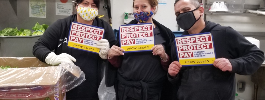 three workers holding UFCW placards
